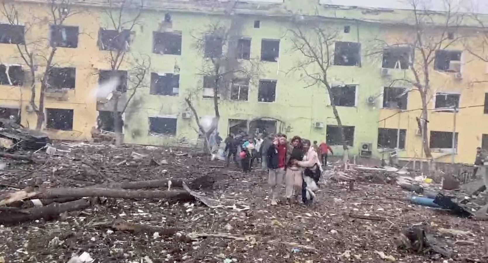 Personas que se encontraban en el hospital huyen de la explosión que ha reducido el inmueble. 