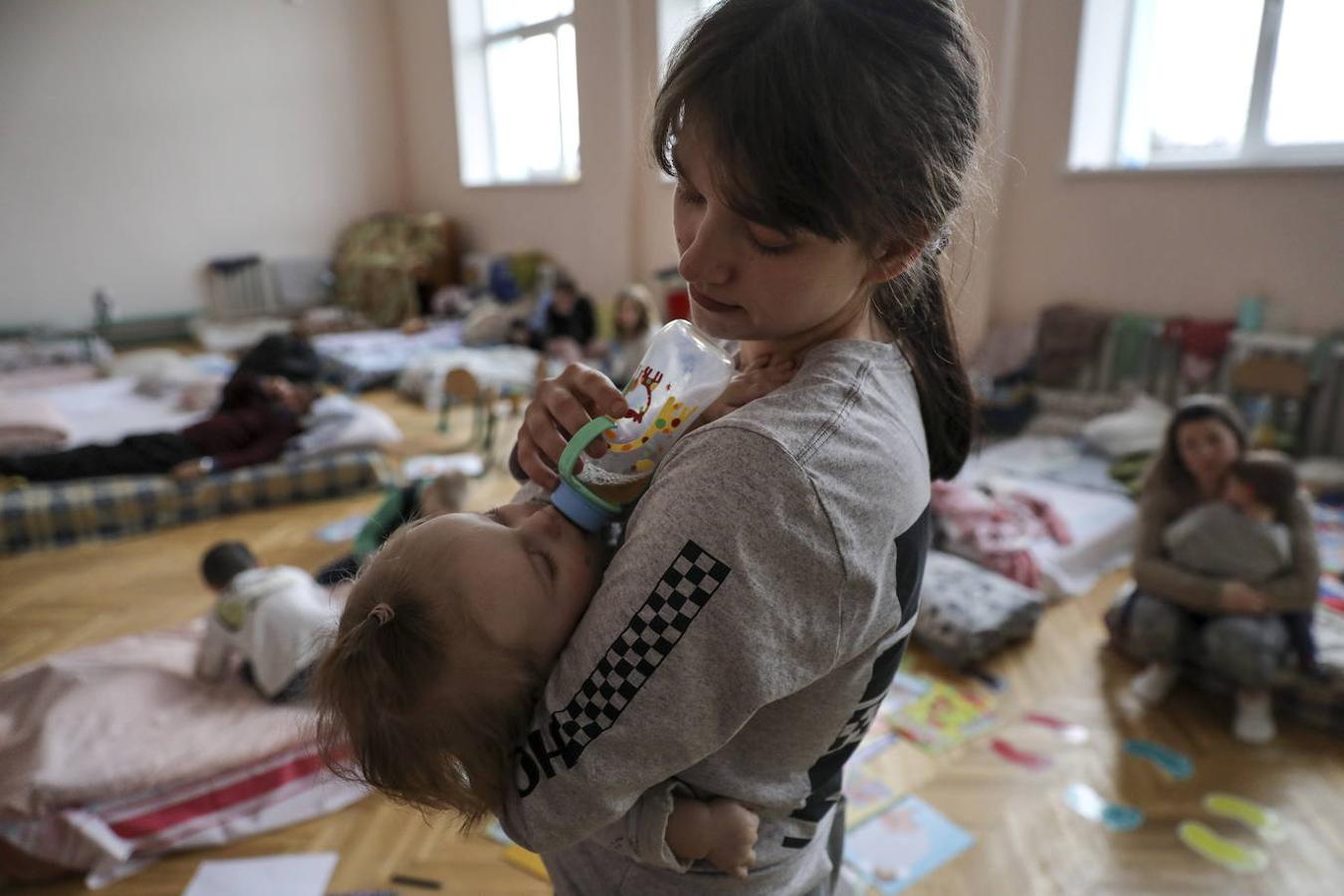 Una madre alimenta a su hijo en un refugio en Leópolis. 