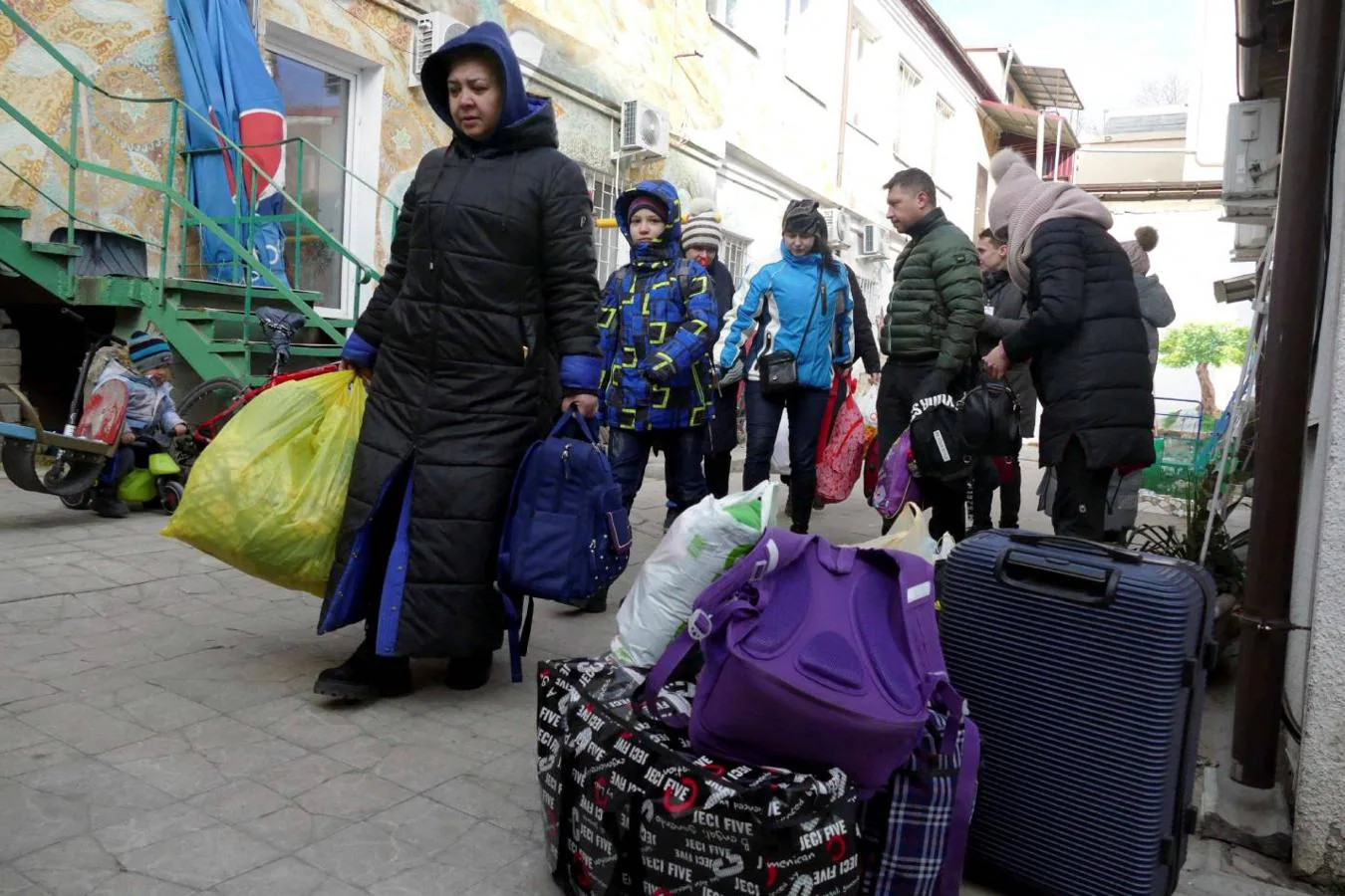 Varios ucranianos portan sus pertenencias mientras huyen de Odesa. 
