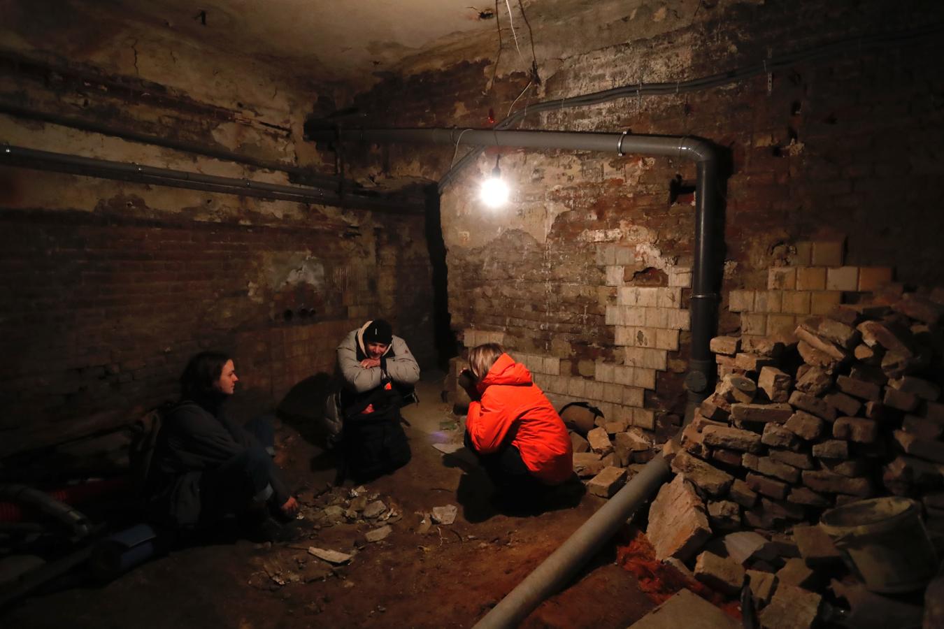 Tres ucranianos se refugian en un sótano tras escuchar las alarmas de ataque en Leópolis. 