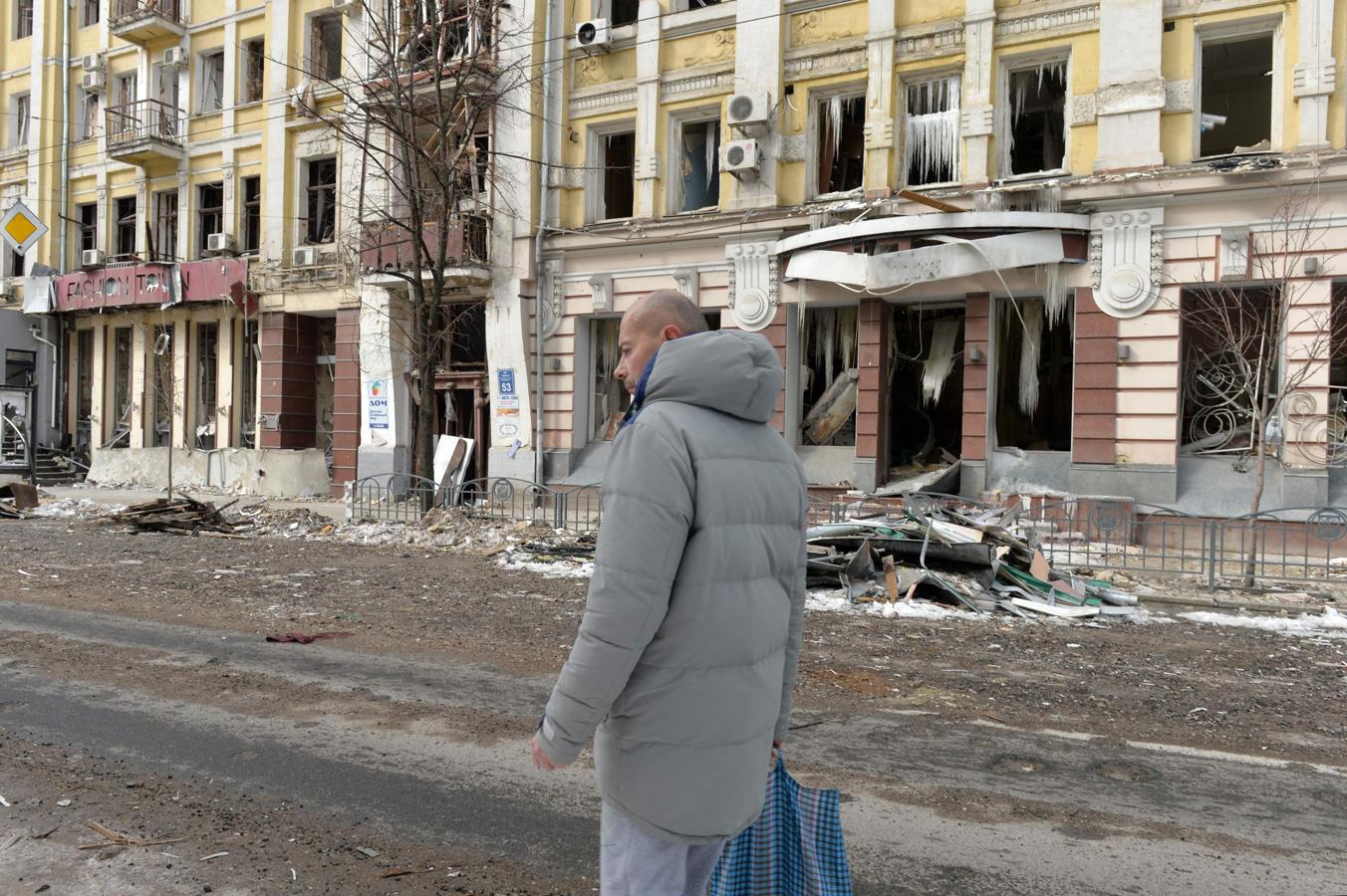 Un hombre pasea enfrente de un edificio en ruinas en Járkov. 