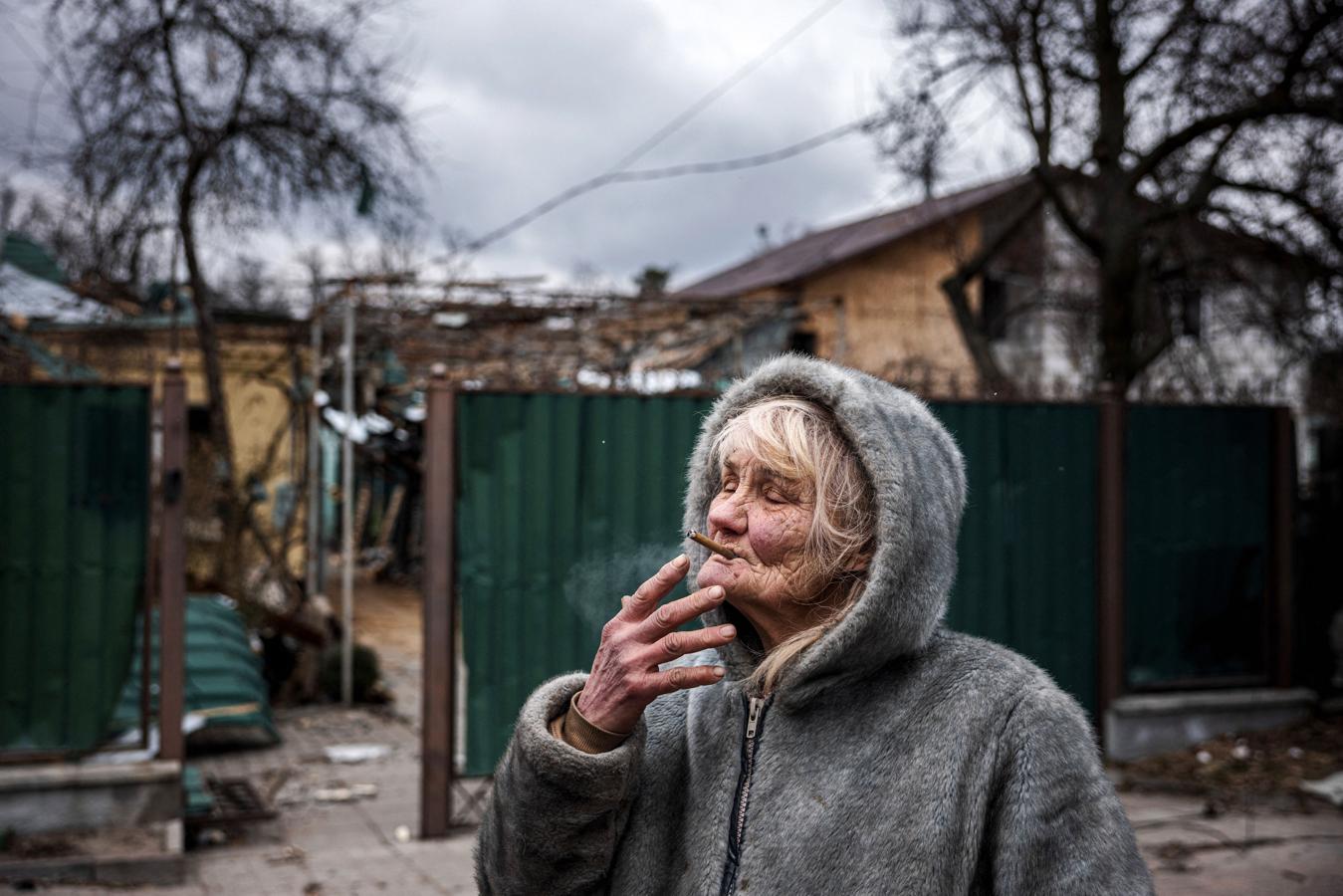 Vera Tsyghanova, 76, fuma un cigarrillo frente a su casa en Kiev. 