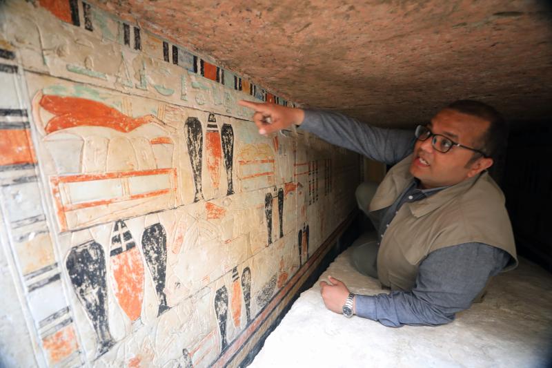 El arqueólogo egipcio Mohamed Elsaedi señala las pinturas dentro de la tumba de una mujer que podría haber sido la esposa de un hombre llamado Iyaret (Foto: EFE)