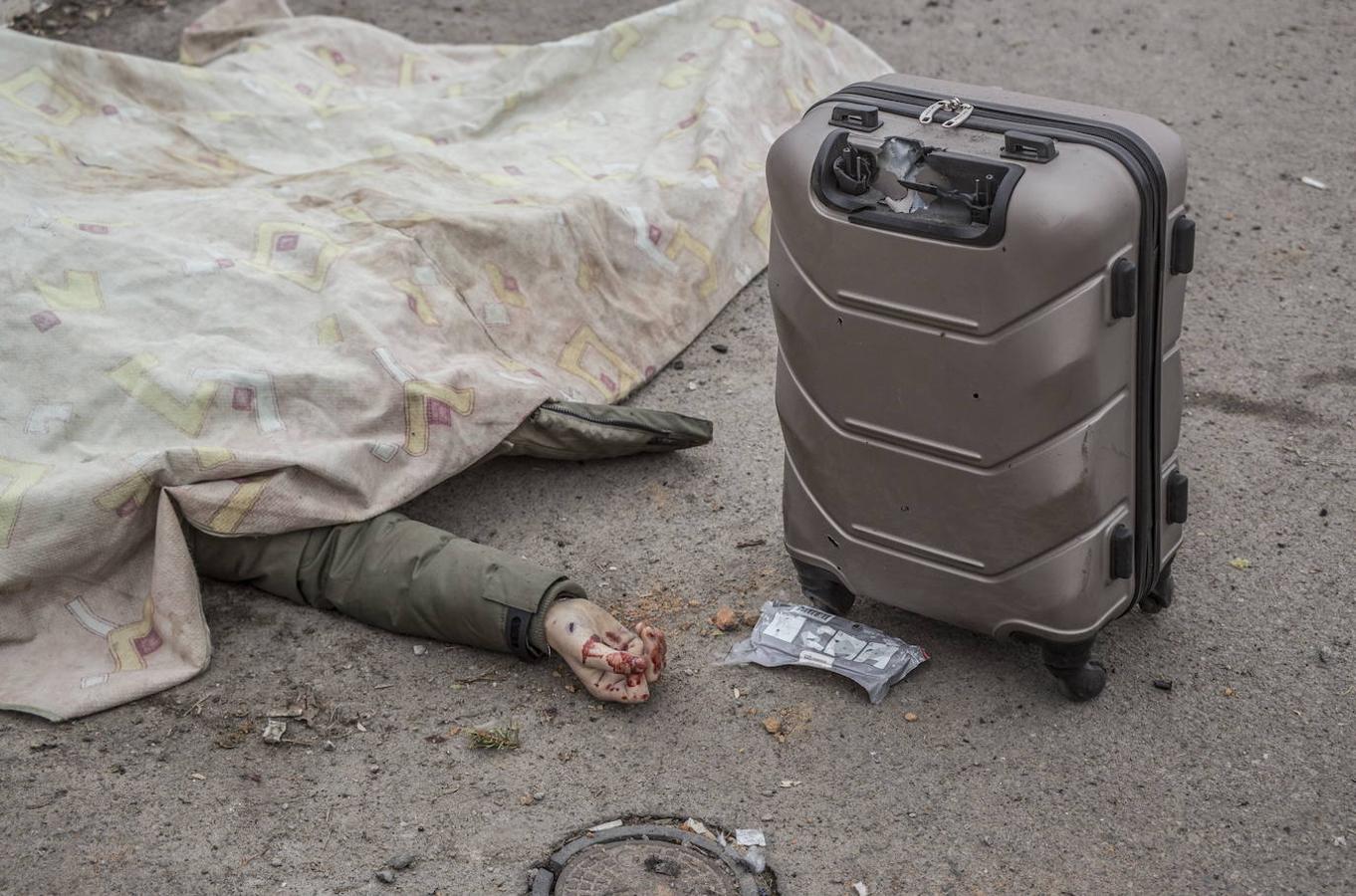 La imagen del horror. El cadáver de una persona alcanzada por los ataques rusos yace en el suelo junto a una maleta tras tratar de huir de Irpin, en los alrededores de Kiev