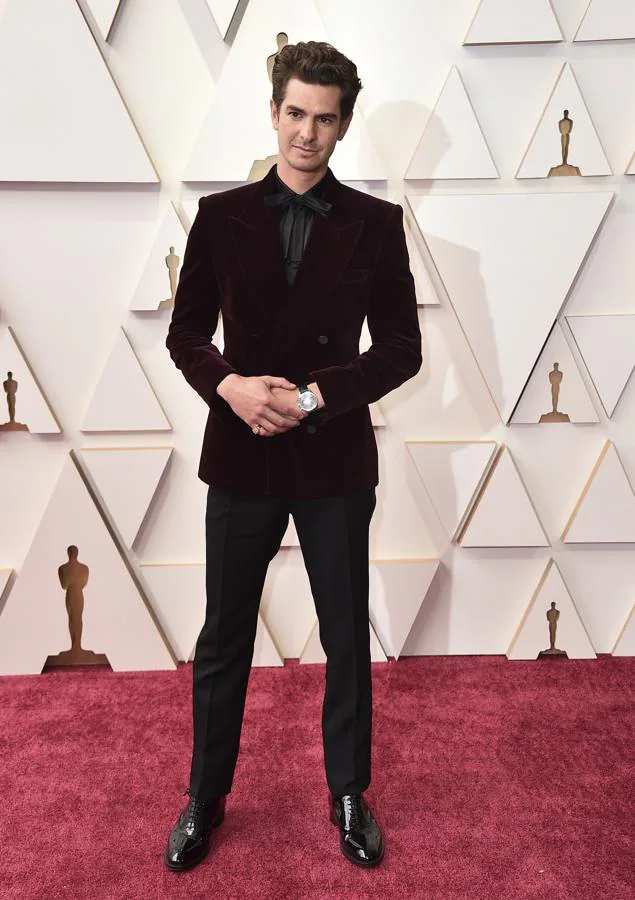 Andrew Garfield - Los mejor vestidos de los Oscar 2022. Apostó por un traje de Saint Laurent compuesto por una blazer de terciopelo burdeos que combinó con una camisa con lazada y pantalón negros.