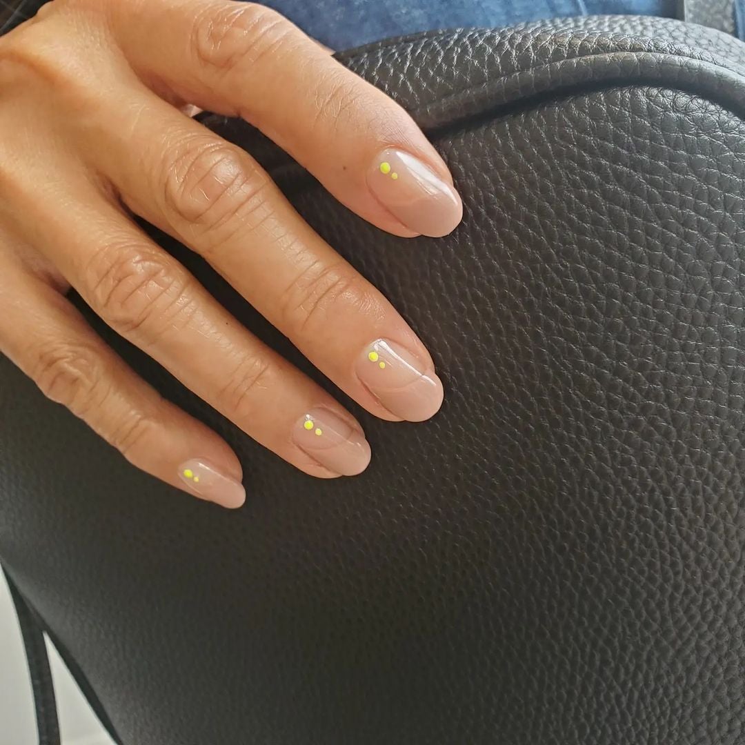 Manicura de puntos. Un diseño de uñas discreto que sigue siendo tendencia esta primavera son los puntos. En este caso se combinan dos puntos en amarillo neón, con la punta en tono beige. (Instagram @miyukinakatomi).
