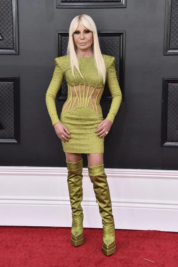 Donatella Versace - Alfombra roja de los Grammy 2022. Lució una creación suya color verde pistacho de lúrex con transparencias que combinó con unas botas mosqueteras a juego con plataforma-