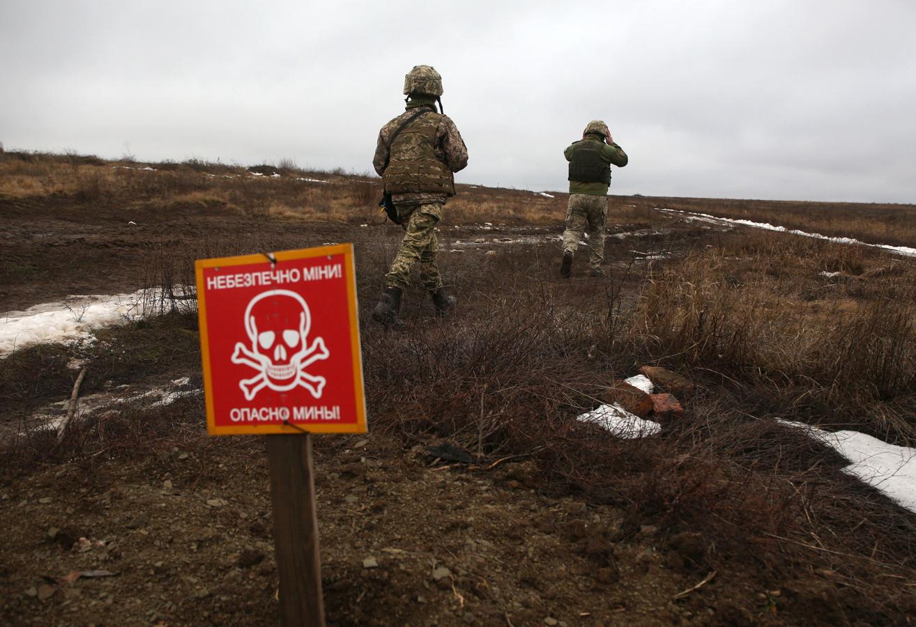 Soldados ucranianos caminan por una zona en peligro por presencia de minas. 
