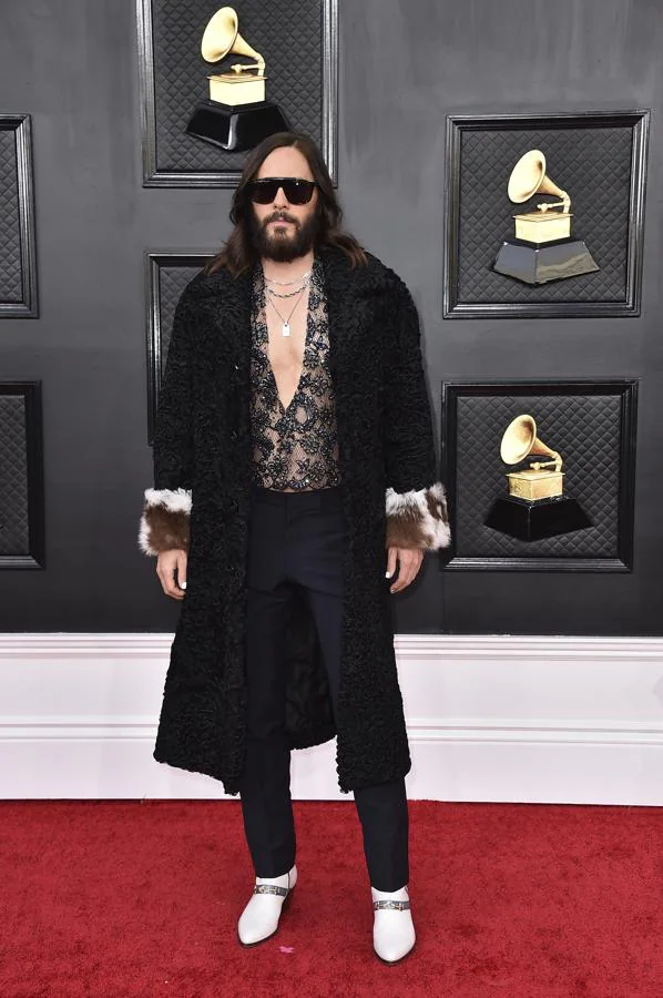 Jared Leto - Alfombra roja de los Grammy 2022. Fiel a Gucci, lució un total look compuesto por una camisa con transparencias y pedrería, pantalones de sastre azul marino y abrigo negro de astracán negro con pelo en los puños.