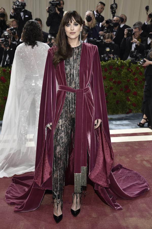 Dakota Johnson - Alfombra roja de la Gala MET 2022. Lució un mono transparente con encaje y flecos de Gucci añ que añadió una capa de terciopelo burdeos.