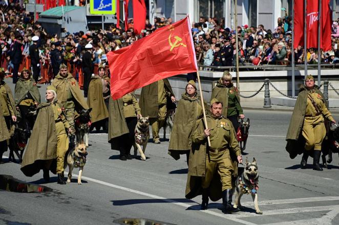 Algunos participantes en el desfile llevan uniformes históricos y símbolos comunistas. 