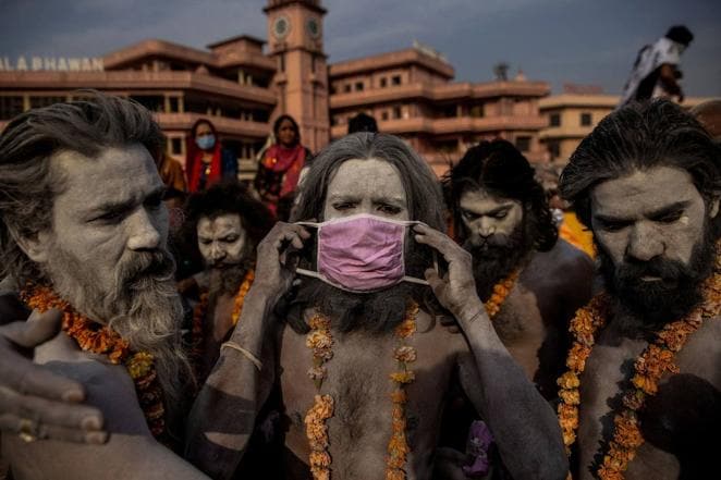 Un 'Naga Sadhu', un hombre santo hindú, se pone una mascarilla antes de entrar en el río Ganges durante el tradicional Shahi Snan, o chapuzón real, en el festival Kumbh Mela en Haridwar, India, el 12 de abril de 2021. Como el Covid estalló en la India en abril y mayo, los hospitales se quedaron sin oxígeno, provocando que muchos pacientes murieran asfixiados