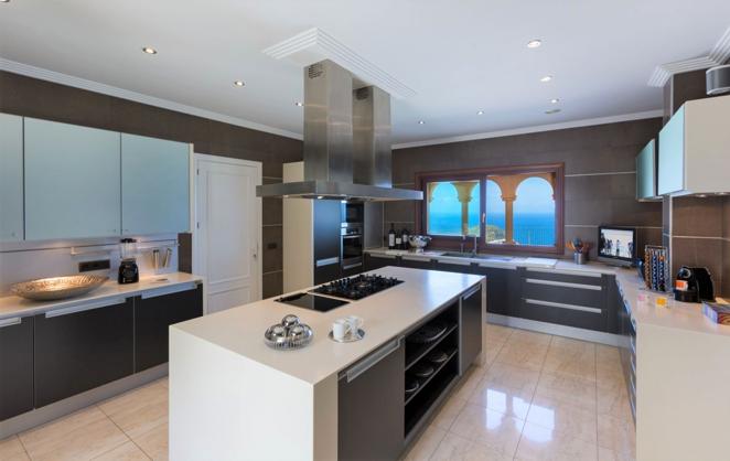 La villa más lujosa de Jávea de 9,5 millones de euros. La cocina resulta de lo más amplia, con una gran isla central y mobiliario de última generación. Aunque la decoración es algo más minimalista que en el resto de estancias, se ve muy elegante.