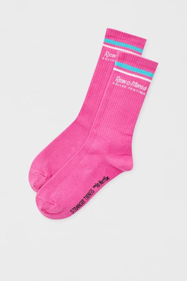 Pull&amp;Bear - Prendas inspiradas en Stranger Things. Calcetines fucsia con rayas bicolor y mensaje bordado, de Pull &amp; Bear. Precio: 4,99€.