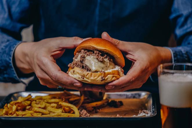 The Food Dealers. Este restaurante de Madrid ha creado la 'burgondiga'. Se trata de una 'burger-albóndiga' que aúna los dos mundos de estas recetas. La albóndiga de 160 gramos va rellena de queso provolone y horneada, se presenta envuelta en un brioche de mantequilla elaborado por Alma Nomad Bakery (vecinos en la misma calle), coronada con más queso 'provolone' fundido y parmesano rallado, se sirve junto a una salsa de guiso y se acompaña de unas patatas fritas caseras con un toque de pimienta. Juan de Austria, 14. Madrid