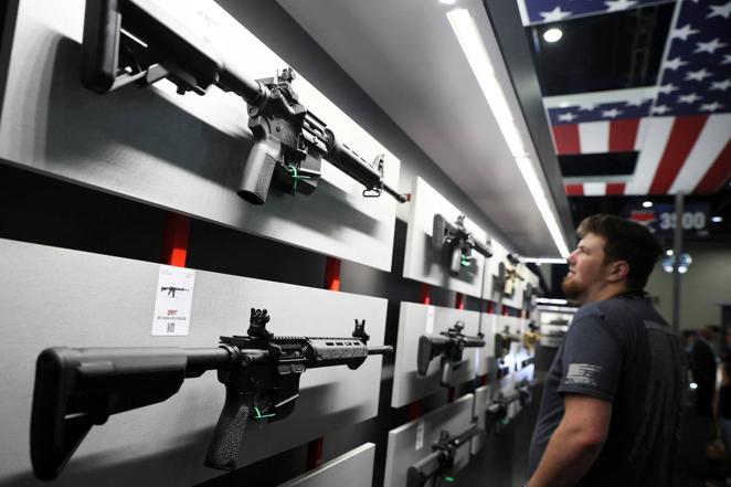 Un hombre mira los rifles de marca Saint durante la Convención Nacional del Rifle, una de las más polémicas de los últimos años, pues se produce pocos días después del tiroteo en la escuela de Uvalde.