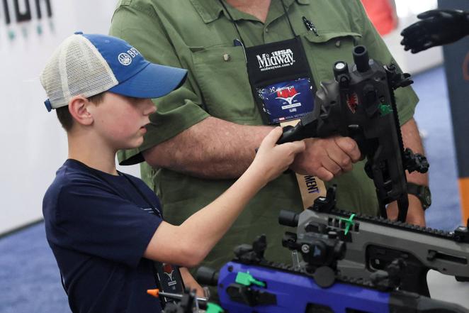 Un niño mira un kit de conversión de pistola en la Convención Nacional del Rifle que se celebra estos días en Houston (Texas).