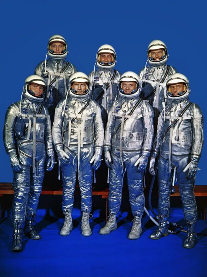 El primer traje de la NASA: Programa Mercury. Tan solo seis meses depués de crear la NASA, EE. UU. presentó sus primeros trajes espaciales, destinados para los astronautas del Programa Mercury. Estos sencillos trajes se basaron en la vestimenta a presión que usaban los pilotos de la marina norteamericana. Los astronautas no hacían paseos espaciales en ese entonces, sólo usaban dentro de la nave espacial. En esta foto, el equipo posa con sus trajes presurizados: Walter M. "Wally" Schirra Jr., Donald K. "Deke" Slayton, John H. Glenn Jr., M. Scott Carpenter. (En primera fila, de izquierda a izquierda a derecha), y Alan B. Shepard Jr., Virgil I. "Gus" Grissom y L. Gordon Cooper, Jr (en segunda fila)