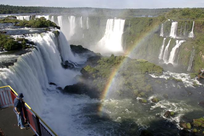 Cataratas de Iguazú, Argentina, Brasil. Son, probablemente, las más espectaculares del mundo. Pueden verse desde el lado brasileño o desde el argentino. El río Iguazú traza la frontera entre los dos países y desemboca en el río Paraná, donde se unen las fronteras de Argentina, Brasil y Paraguay. Las cataratas están formadas por 275 saltos, el 80 % de ellos en el lado argentino. Hay diferentes recorridos organizados, para mojarse más o menos, e incluso se pueden visitar en helicóptero.