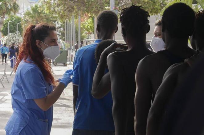 Dos sanitarias atienden a decenas de inmigrantes han entrado este viernes en Melilla. 