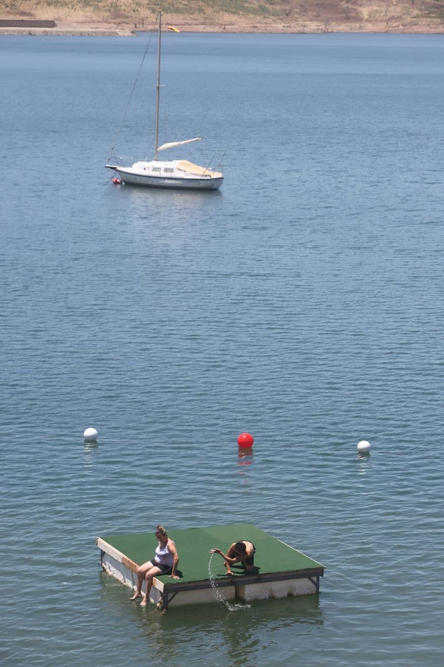 En imágenes, el primer baño veraniego en la playa del embalse de la Breña