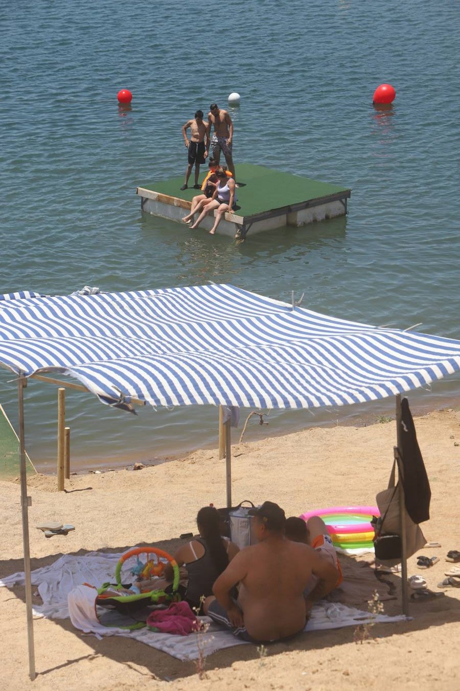 En imágenes, el primer baño veraniego en la playa del embalse de la Breña