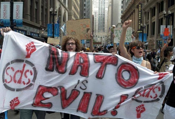 19 de mayo de 2012. Manifestantes gritan consignas y portan pancartas contra la cumbre de la OTAN, durante una protesta en el centro de Chicago (Estados Unidos). Los líderes de la OTAN debatieorn en aquella cumbre definir su papel en Afganistán tras la retirada del grueso de sus fuerzas en 2014.. 