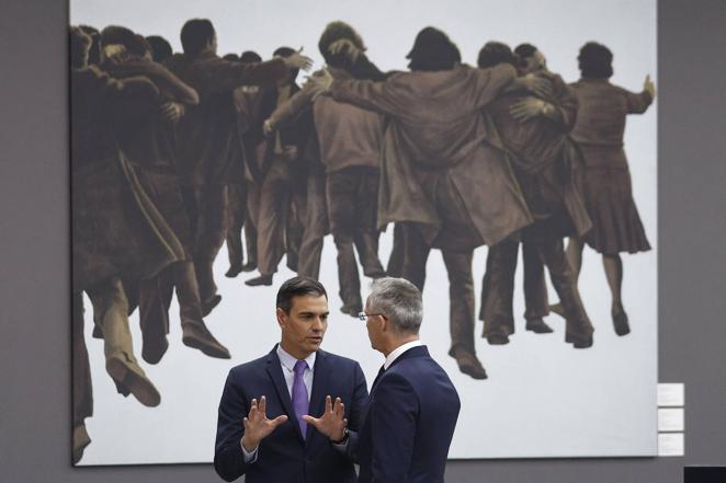 Sánchez y Stoltenberg conversan en IFEMA ante el cuadro 'El Abrazo', de Juan Genovés, un símbolo de la Transición democrática española.. 