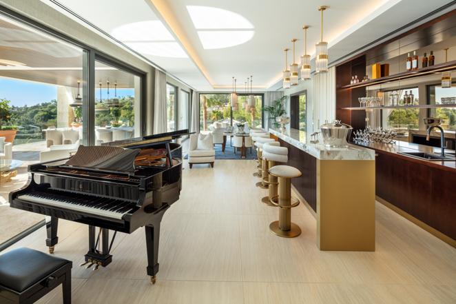 Villa Olympus, una mansión de lujo en Marbella. Zona de bar con piano y vistas al exterior.