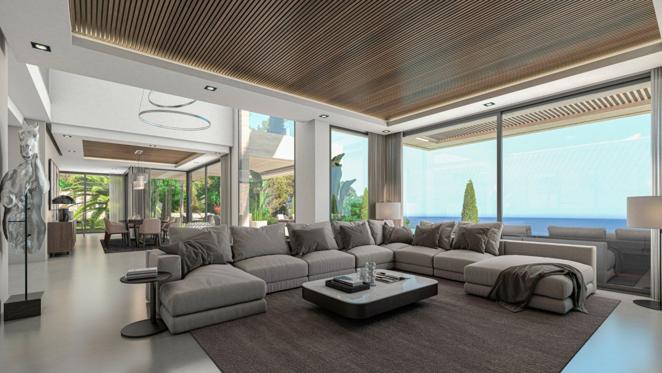 Una villa de lujo frente al mar en Jávea. El salón, decorado en tonos tierra, dispone de un gran sofá y acceso directo al jardín, así como de unas privilegiadas vistas al mar. La vivienda también incluye un gimnasio y una habitación de juegos.