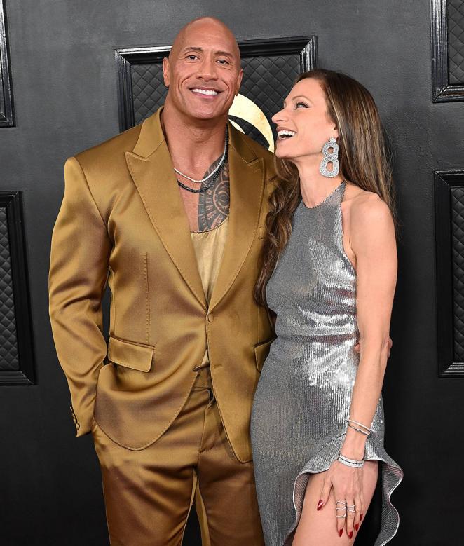The Rock con collar de diamantes. El actor, que posó en la alfombra roja con su esposa, eligió un sencillo collar de diamantes para combinar con su traje dorado.