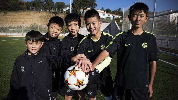 Varios niños posan con un balón de fútbol