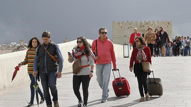 Turistas pasean por el Puente Romano de la capital