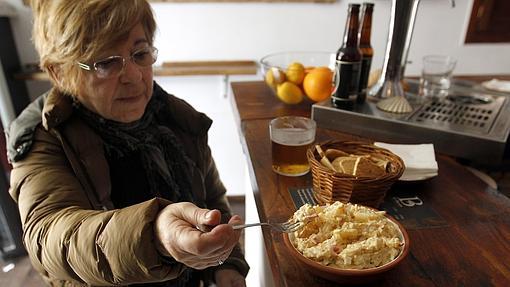 Una clienta da buena cuenta de la ensaladilla de El Barón