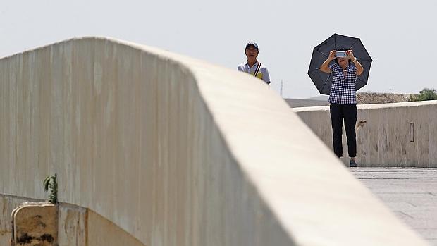 Una pareja de turistas orientales en el Puente de Miraflortes