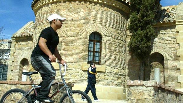 Un ciclista pasea delante de la ermita de los Mártires