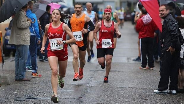 El ganadora femenina entra en la lína de meta bajo la lluvia