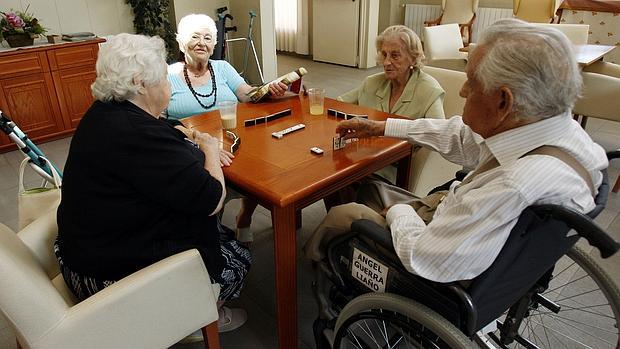 Ancianos juegan al dominó en una residencia de mayores