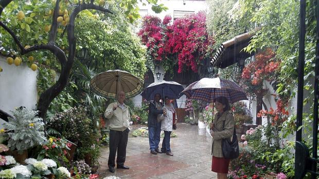 Visitantes con paraguas en uno de los patios