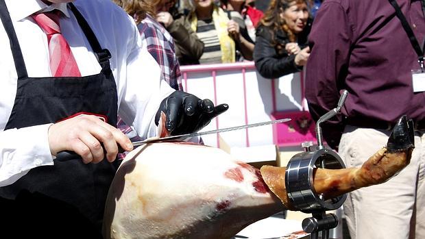 Un cortador con una pieza de jamón ibérico de pata negra