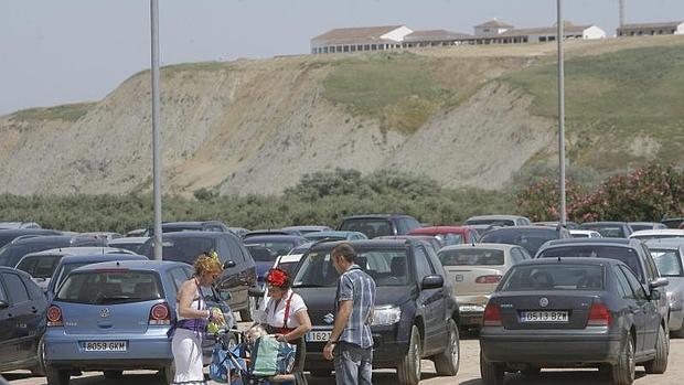 Dos mujeres vestidas de flamencas y con un carrito abonan el importe del aparcamiento