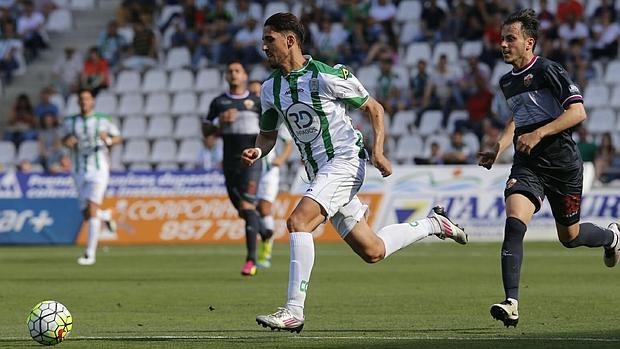 Fidel conduce el esférico perseguido por Espinosa en el Córdoba CF-Elche de esta tarde