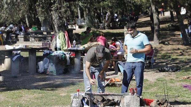 Dos personas cocinan carne en Los Villares