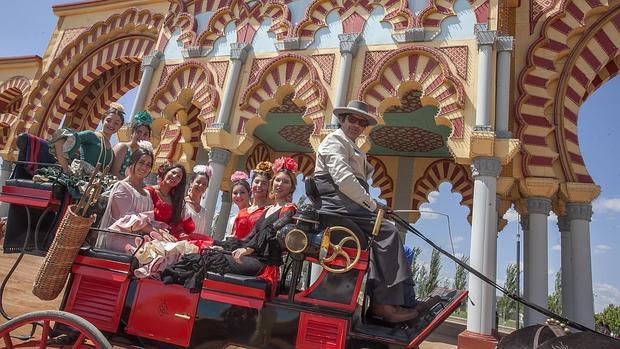 Un grupo de jóvenes, en un enganche ante la portada de la Feria de Córdoba