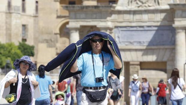 Un turista se protege del sol en el Puente Romano