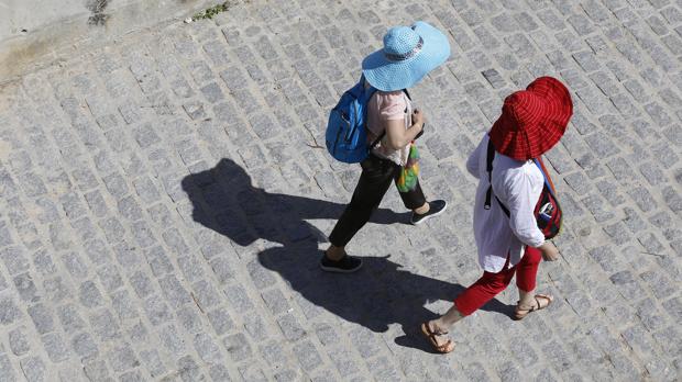 Dos turistas y sus sombras por las calles de Córdoba