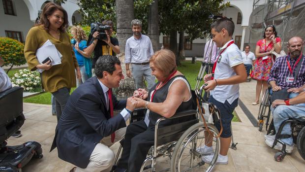 El presidente del PP andaluz saluda a una de las representantes de las asociaciones de discapacitados que visitó ayer el Parlamento