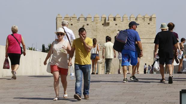 Turistas pasean por el Puente Romano en verano