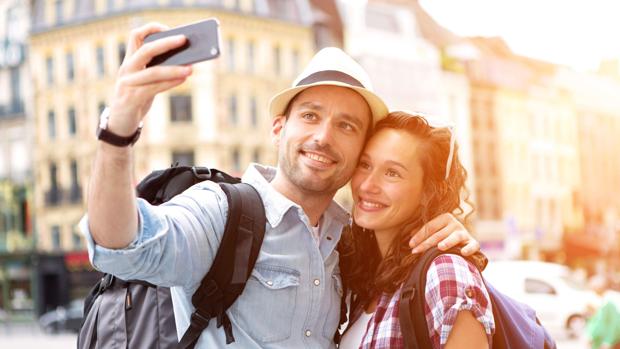 Una pareja sonrie para hacerse un selfie durante sus vacaciones