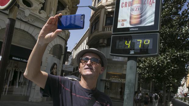 Un hombre se hace un «selfie» con un termómetro en el centro